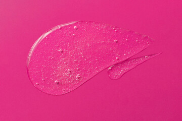 Smear of white gel with bubbly texture,looks like cosmetic drop.Jelly texture of antibacterial liquid.Bright pink background with copy space,advert banner.
