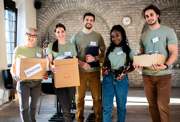 Portrait of volunteers with working in community charity donation center.