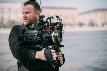 Director of photography with a camera in his hands on the set. Professional videographer at work on filming a movie