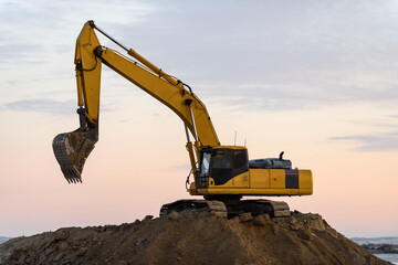 Yellow excavator working on construction site. The road construction. © Alexey Seafarer