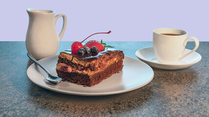 a piece of delicious homemade cake on a plate and a cup of tea on a saucer on a wooden kitchen table