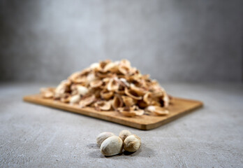 A couple hard to open pistachios and many empty shells in the background