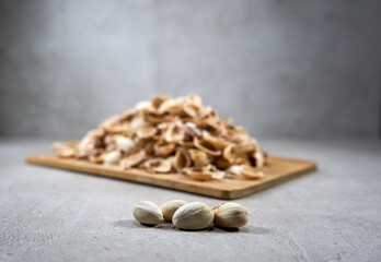 A couple of pistachios in the front and many empty shells in the background