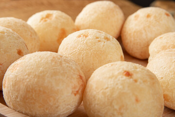 Brazilian Cheese bread, cheese breads arranged on wooden plate, on rustic wood, selective focus.