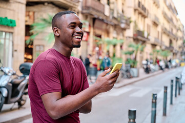 young man using smartphone aoutdoors in the middle of the street