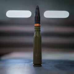 A large-caliber bullet on a blurry background. Weapon. A picture illustrating the weapon.