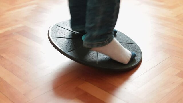 Kids Feet During Training. Home Gym Workout Equipment. Using A Balance Disc For Exercise On The Wooden Parquet Floor. 