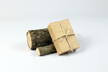 Craft paper gift box and wooden logs isolated on white background. Handmade gift concept. Part of set.