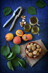 Fototapeta na wymiar Jars of apricot kernel oil. Apricots, leaves, seeds.