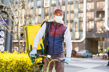 Obraz premium Young delivery man with yellow backpack takeaway concept