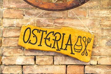 A wooden sign with the inscription Osteria