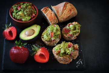 Toast with strawberry guacamole. Healthy summer snack. Avocado with strawberries. Keto diet toast.