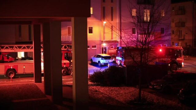 Fire brigade arrived at the scene. Flashing lights in courtyard of apartment building in evening. View of observer in residential area. Fire brigade to emergency response, city lifestyle