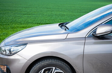The car is parked in front of a young green field. Hyundai i30