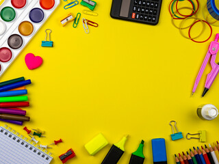 School supplies on a bright yellow background. Stationery on a yellow table. School concept. Back to school. Paints, pencils, rulers and other school items for study