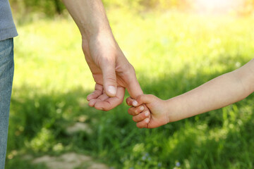 the parent holding the child's hand with a happy background