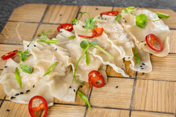 Jiaozi chinese dumplings named gyoza on wooden plate. Asian traditional fast food. Dough dish stuffed with meat and vegetables, less often only meat.