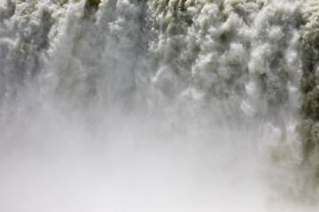 Natural background. Power in water. Closeup view of the famous Iguazu falls in Misiones, Argentina. The mist and falling white water beautiful texture, motion and pattern.