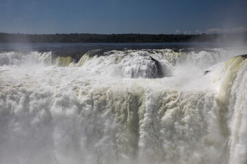 Nature's power. View of the Iguazu waterfalls and river, seen from Garganta del Diablo, in Misiones, Argentina. The amazing falls and falling white water beautiful texture, mist and splash.