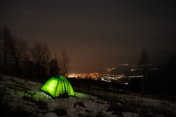 Fototapeta na wymiar Yellow tent in winter forest at night