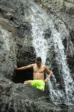 Hombre joven parado en una cascada