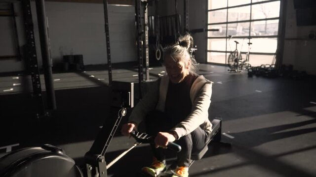 Senior Man Using Rowing Machine In Gym