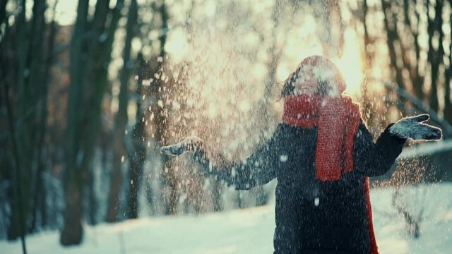 beautiful happy female playing with snow and have fun outdoor in winter park