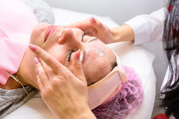 Facial massage at the beautician at the reception, visiting a beauty salon, a sense of relaxation.