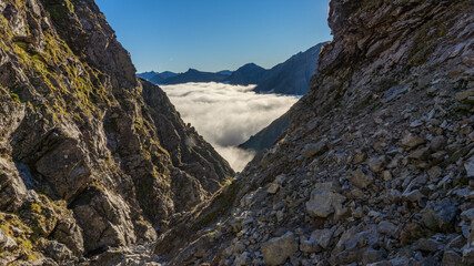 Foggy valley surrounded by the mountains.