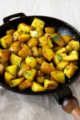 Homemade Roasted Potatoes with Mustard Seeds in a cast-iron pan, side view.