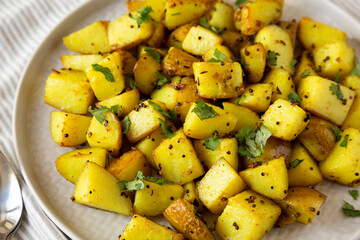 Homemade Roasted Potatoes with Mustard Seeds on a Plate, side view. Close-up.