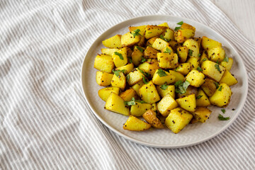 Homemade Roasted Potatoes with Mustard Seeds on a Plate, side view. Space for text.