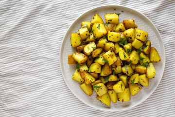 Homemade Roasted Potatoes with Mustard Seeds on a Plate, overhead view. Flat lay, top view, from above. Copy space.