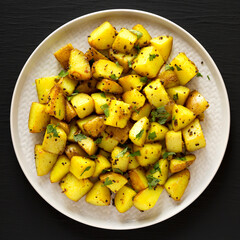 Homemade Roasted Potatoes with Mustard Seeds on a Plate, top view. Flat lay, overhead, from above.