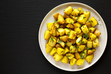 Homemade Roasted Potatoes with Mustard Seeds on a Plate, top view. Flat lay, overhead, from above. Copy space.