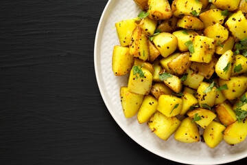 Homemade Roasted Potatoes with Mustard Seeds on a Plate, top view. Flat lay, overhead, from above. Copy space.