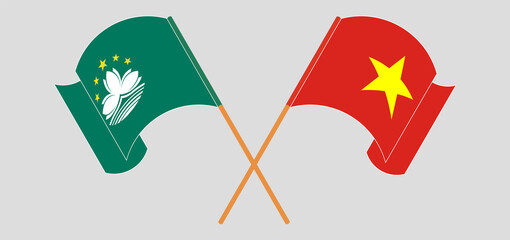Crossed and waving flags of Macau and Vietnam