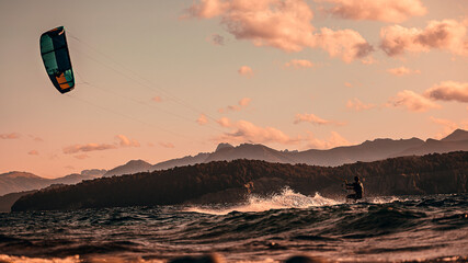 Hombre haciendo kitesurf en un lago al atardecer