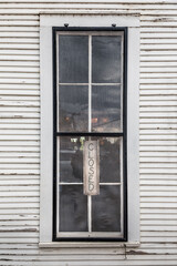 Old store window with a closed sign in the window in Texas