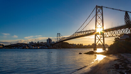 Pôr do sol e  raios solares ultrapassando a estrutura da Ponte Hercílio Luz , Santa Catarina, Brasil, florianopolis , Florianópolis