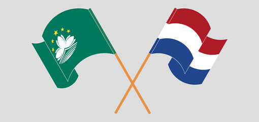 Crossed and waving flags of Macau and the Netherlands