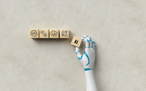 robot hand adding a cube with the message AI to four others with tech symbols on concrete background