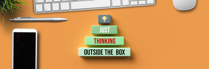boxes with text JUST THINK OUTSIDE THE BOX amd computer equipment on orange background