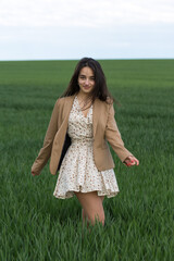 Portrait of a positive cheerful brunette girl in a green spring park.