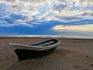 Green boat on the beach at dawn 2