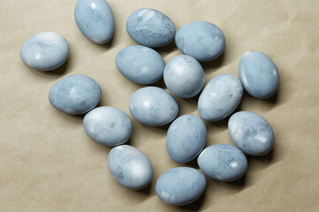 Fototapeta na wymiar Colored blue-gray marble eggs lie randomly on the craft paper