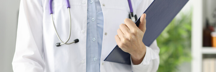 Silhouettes of doctor holding clipboard in medical office