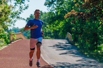 Handsome man jogging during sunny morning out on the race track