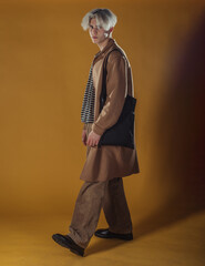 Portrait of a smart young man standing against yellow backgroun