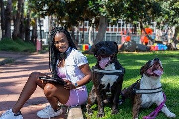Afro girl in the park with her two dogs